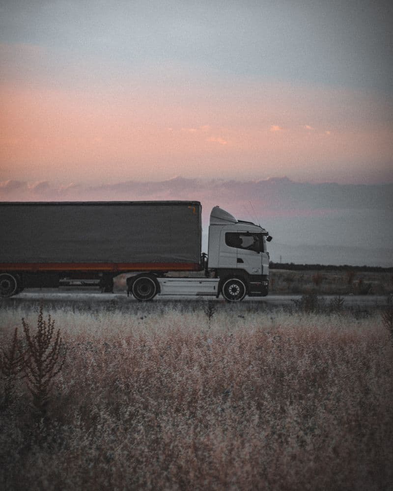 Tractor-trailer on an open road at dusk