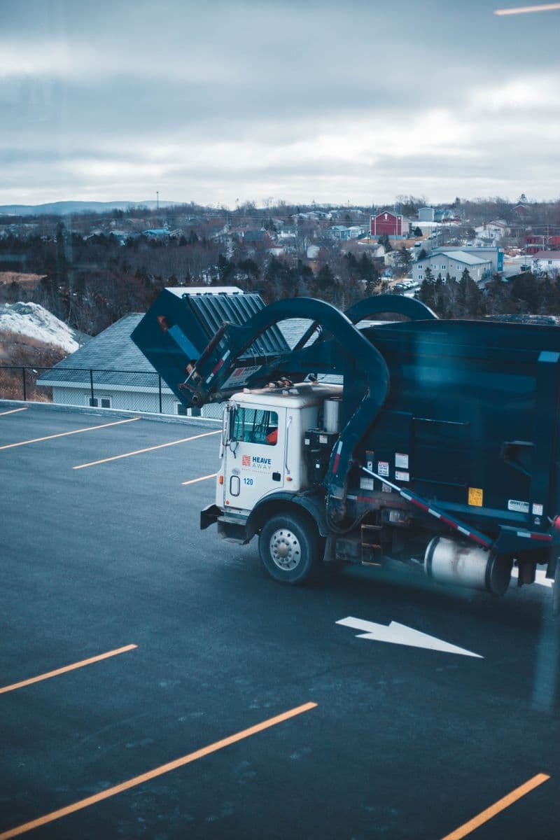 Garbage truck emptying a commercial waste bin